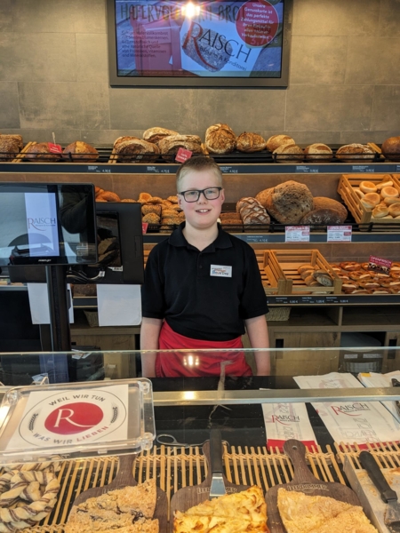 Junge hinter einer Bäckereitheke