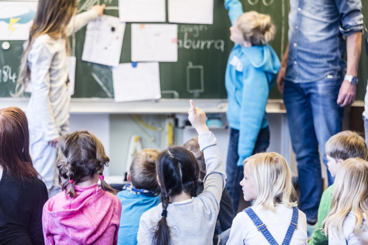 Grundschulkinder vor einer Tafel